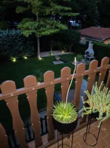 a wooden fence with chairs and a garden at night at Era Apartmanház in Harkány