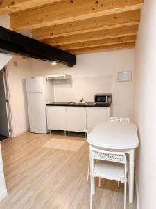 a kitchen with a white table and a white refrigerator at Posada Inés in Castro-Urdiales