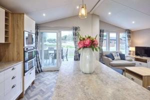 a kitchen with a vase with flowers on a counter at The Haven Lodge with Hot Tub in York +23 photos