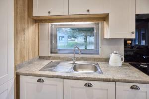 a kitchen counter with a sink and a window at The Haven Lodge with Hot Tub in York