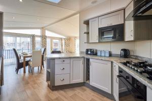 a kitchen with a counter top and a dining room at Penny Lodge with Hot Tub in Malton