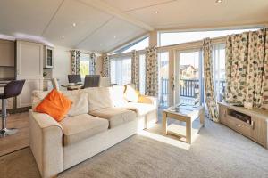 a living room with a couch and a table at Penny Lodge with Hot Tub in Malton