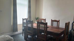 a dining room with a wooden table and chairs at stone cottage in Fir Tree