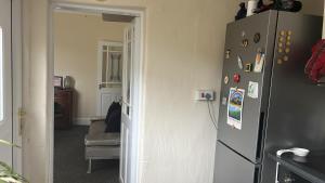 a kitchen with a refrigerator with magnets on the wall at stone cottage in Fir Tree