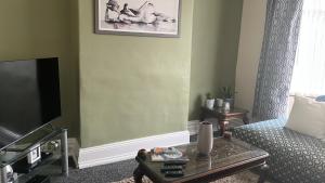 a living room with a couch and a tv at stone cottage in Fir Tree
