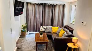 a living room with a leather couch and a table at Sleeps 5 Free Parking Fast WiFi Near Hillsborough Easy Access to Sheffield City Centre and Peak District in Hillsborough