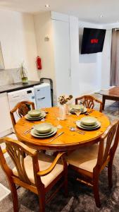 a wooden table with plates on it in a kitchen at Sleeps 5 Free Parking Fast WiFi Near Hillsborough Easy Access to Sheffield City Centre and Peak District in Hillsborough +31 photos