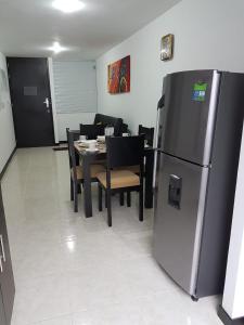a kitchen with a refrigerator and a table with chairs at Aptos hermosos en sector turistico in Montenegro +3 photos