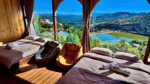 two beds in a room with a large window at Mimoza homestay cầu đất in Xuân Trường