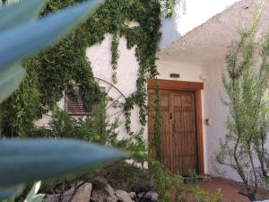 una entrada a una casa con puerta de madera en Casa Rural Santa Ana, en Miguel Esteban