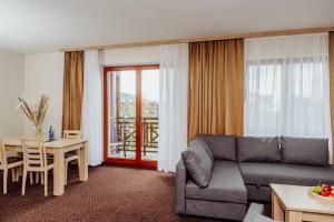 ein Wohnzimmer mit Sofa und Tisch in der Unterkunft Instytut Zdrowia Sofra FIT & SPA in Karpacz