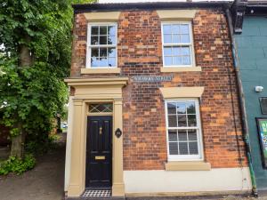 a brick house with a black door and windows at 35 Wrawby Street in Brigg