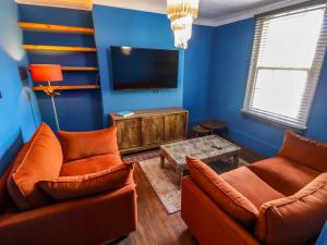 a living room with two couches and a flat screen tv at 35 Wrawby Street in Brigg
