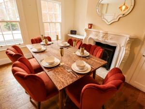 a dining room with a table and chairs and a fireplace at 35 Wrawby Street in Brigg