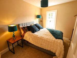 a bedroom with a bed with pillows and a window at 35 Wrawby Street in Brigg