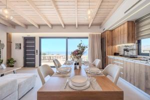 a living room with a table and chairs and a kitchen at Rodia Luxury Villa in Plakias