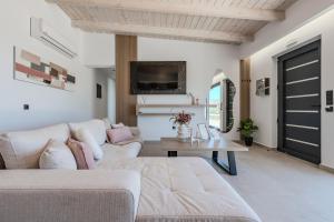 a living room with a couch and a table at Rodia Luxury Villa in Plakias