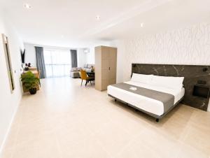 a bedroom with a large bed and a living room at AH Rentals in Vinarós