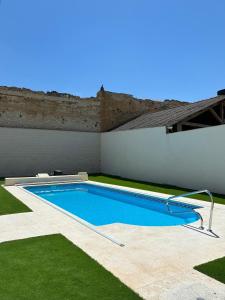 a swimming pool in a yard with green grass at El gallinero de Valoria in Valoria la Buena