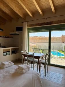 a bedroom with a table and a dining room with a view at El gallinero de Valoria in Valoria la Buena +19 photos