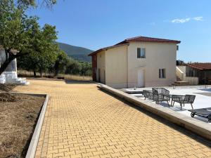 a patio with benches and a building and a house at Olive Hill Guest House in Limenas