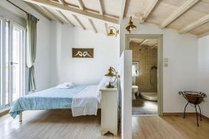 a bedroom with a bed and a bathroom at Villa Calma in Patitiri