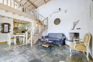 a living room with a staircase and a couch and a table at Villa Calma in Patitiri