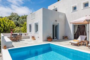 a villa with a swimming pool in front of a house at Villa Calma in Patitiri
