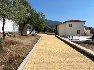 a brick walkway in a yard with a house at Olive Hill Guest House in Limenas