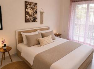 a bedroom with a large white bed with a window at Stavros Green & Sea Holiday Home in Stavros