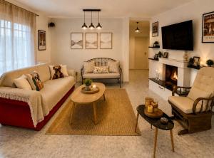 a living room with a couch and a fireplace at Stavros Green & Sea Holiday Home in Stavros