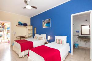 um quarto com 2 camas e uma parede azul em Hotel Pousada Vivendas do Sol e Mar em Caraguatatuba