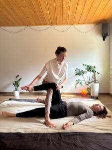 a woman sitting on top of a woman laying on a bed at Chata Romanka in Sopotnia Mała