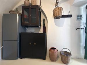 a kitchen with a refrigerator and a cabinet and baskets at Mylopotamos House in Milopótamos