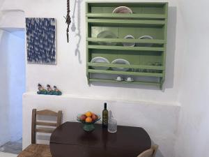 a table with a bowl of fruit and a green cabinet at Mylopotamos House in Milopótamos +8 photos
