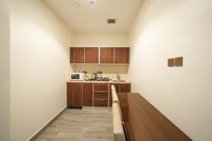 a kitchen with wooden cabinets and a counter top at جولدن بوجاري الضيافه in Khamis Mushayt