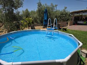 a swimming pool with two chairs and an umbrella at Cazorla Ortiz chalet in Pozo Alcón