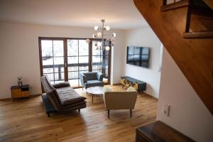 a living room with a couch and chairs and a chandelier at Ferienwohnung Daniel in Garmisch-Partenkirchen