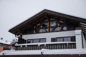 a house covered in snow with a balcony at Ferienwohnung Daniel in Garmisch-Partenkirchen