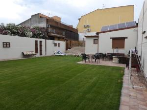 a backyard with a lawn with a table and chairs at Casa Rural Arroyo 5 in Mejorada