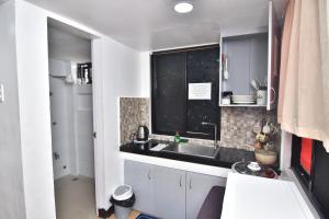 a small kitchen with a sink and a window at Kazoku Hostel in Olongapo +32 photos