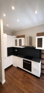 a kitchen with white cabinets and a black counter top at Appartamento Doglio Lux in Cagliari