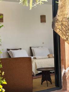 a bedroom with a bed and a table and a mirror at Villa Quince in Ouirgane