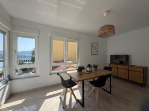 a dining room with a table and chairs and windows at A Casa do Miradoiro in Puentedeume