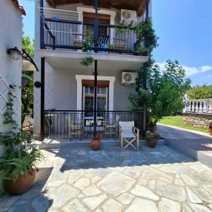 a patio of a house with chairs and a balcony at Georgia apartments in Stafylos