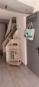 a room with a staircase with a book shelf and a purse at maison de village in Thuir +3 photos