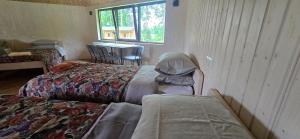 a room with three beds and a table and a window at Mäe Puhkemaja in Rosma