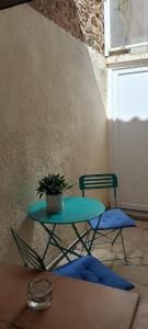 a table and a chair with a potted plant on it at maison de village in Thuir