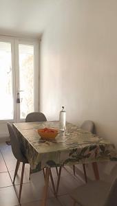 a dining room table with a bowl of fruit on it at maison de village in Thuir