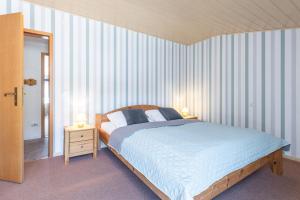 a bedroom with a bed and two lamps on tables at Ferienhaus Neeb in Gammendorf